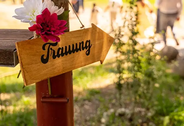 Wegweiser zur freien Trauung mit Blumenschmuck