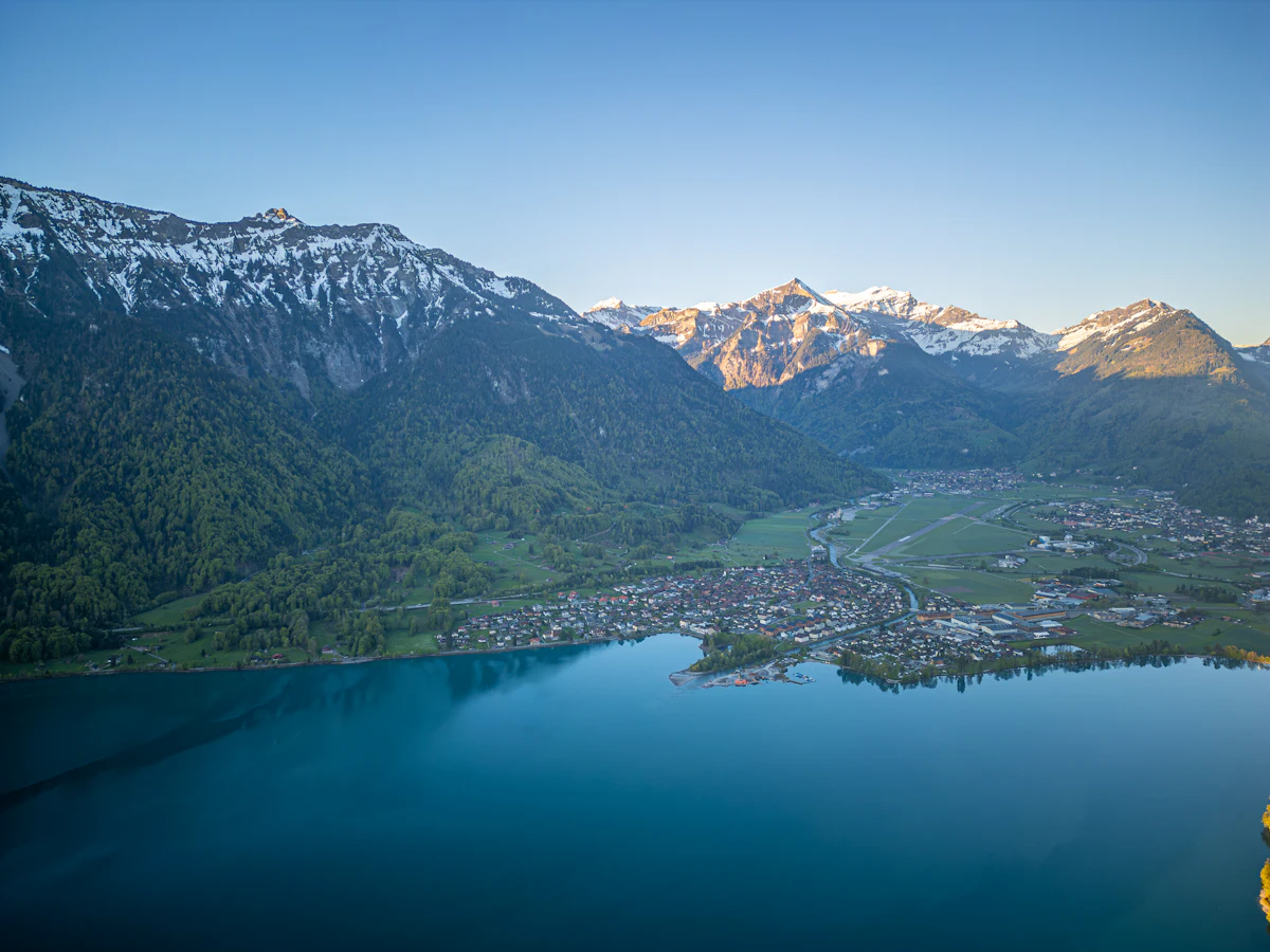 Luftaufnahme eines Alpensees mit Dorf und Bergen (Symbolbild)